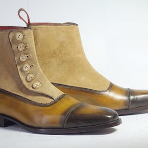 Close-up of artisan button boots on a wooden shelf featuring hand-stitched buttons and cap-toe leather detail.