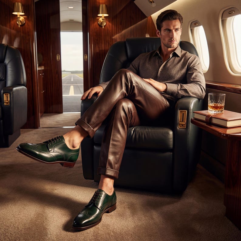 Men's luxury footwear green leather brogues worn in a private jet cabin setting.