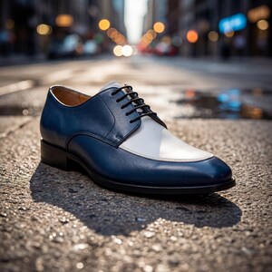 Close up of men's blue dress shoes with white leather vamp and black laces on a city street.