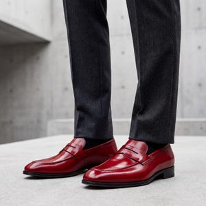 Detailed view of the leather sole and stacked heel of a handmade red loafer.