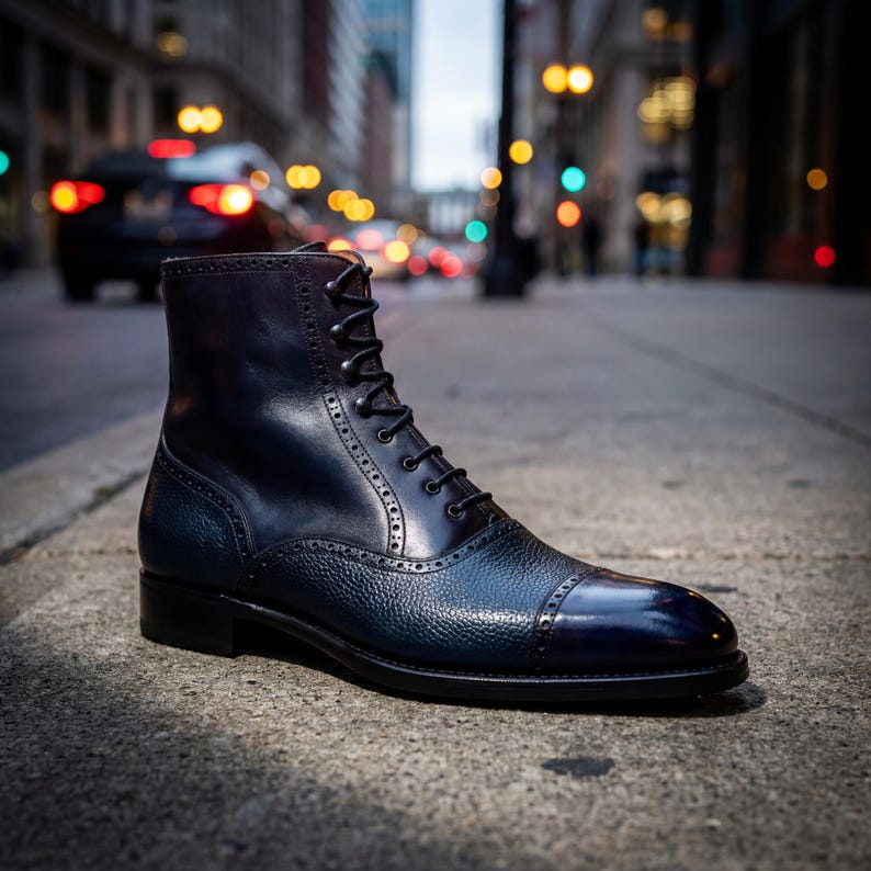 Close-up of pebble grain leather texture and brogue detailing on a blue lace-up boot.