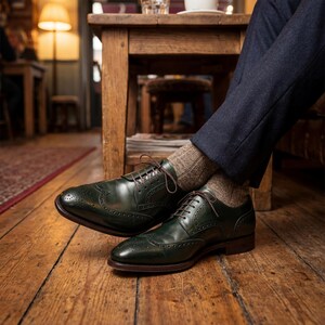 Close-up of green calfskin leather brogues showing high-quality stitching and texture.