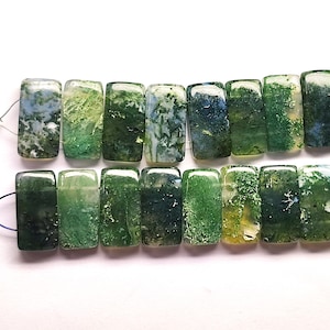 May include: A string of rectangular moss agate beads. The beads show a mix of green, white, and blue hues, with a natural, organic pattern. The beads are strung together, ready for jewellery making.