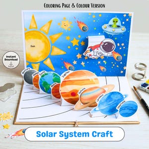 May include: A pop-up solar system craft with the sun, planets, an astronaut, and an alien in a spaceship. The planets are labeled and include Mercury, Venus, Earth, Mars, Jupiter, Saturn, Uranus, and Neptune. The background is blue with stars and comets.