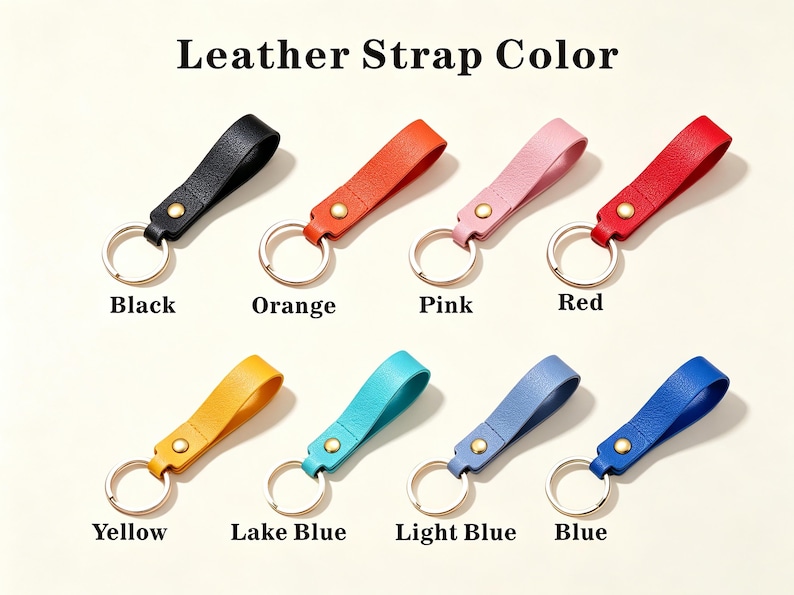 May include: Eight leather keychains arranged in two rows with the text Leather Strap Color above. Each keychain features a textured leather loop in black, orange, pink, red, yellow, lake blue, light blue, or blue, secured by a gold rivet and ring.