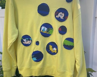Disney upcycled sweatshirt reworked to feature round holes with Disney characters