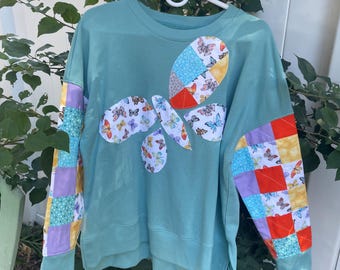 Upcycled sweatshirt reworked to feature a butterfly with quilted sleeves