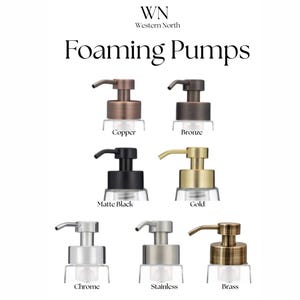May include: An image showcasing various foaming pump dispensers in copper, bronze, matte black, gold, chrome, stainless steel, and brass finishes. The dispensers have clear glass bottles and are labeled with their respective metal finishes. The text "Foaming Pumps" is displayed.