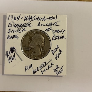 Könnte beinhalten: Eine seltene 1964 Washington Quarter Dollar Münze aus Silber, in einem Schutzhalter präsentiert. Handschriftliche Notizen auf dem Halter lauten "1964-WASHINGTON QUARTER DOLLAR SILVER RARE" und weitere Markierungen.