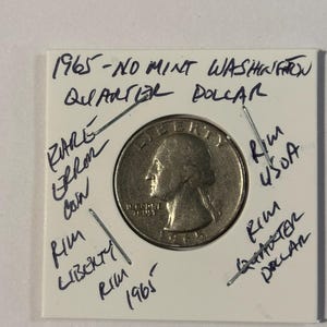 Może przedstawiać: Ćwierćdolarówka Waszyngtona z 1965 roku w ochronnym uchwycie. Moneta jest srebrna i przedstawia profil osoby po jednej stronie. Ręcznie pisane notatki opisują cechy monety.