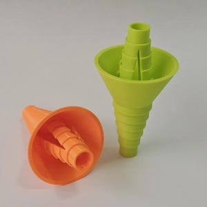 May include: Two plastic funnels, one orange and one green, are displayed against a white background. The orange funnel is on its side, while the green one stands upright. Both have a cone shape with a spiral design.
