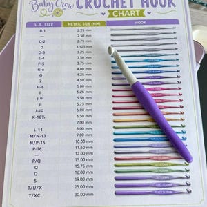 May include: A crochet hook chart titled "The Baby Crow Crochet Hook Chart" with U.S. sizes and metric sizes in millimeters. A purple and white crochet hook is on the chart. The chart includes hook sizes from B-1 to T/XC.