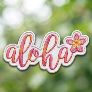 May include: Embroidered patch with the word "aloha" in a cursive font, featuring a pink and orange gradient. A pink flower with a yellow center is attached to the right side of the word. The patch has a white border and is set against a blurred green background.