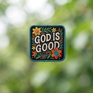 May include: Embroidered patch with the words "GOD IS GOOD" in white script. The patch is square with rounded corners and features colorful floral and leaf designs in orange, yellow, and teal against a black background.