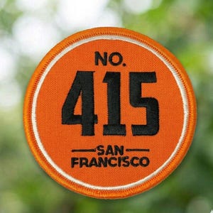 May include: A white ceramic mug with a black handle and the text "But First, Coffee" in a bold, black font. The mug is set against a blurred background, suggesting a cozy setting. The mug appears to be approximately 4 inches tall.