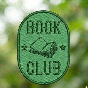 May include: Green embroidered patch with the words "BOOK CLUB" arched over and under an open book illustration. Two stars flank the book image. The patch has an oval shape with a green border.