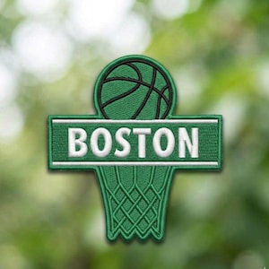 May include: Embroidered patch featuring a green basketball above a green basketball hoop. The word "BOSTON" is embroidered in white on a green rectangular banner. The patch is designed with a sports theme.