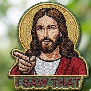 May include: Embroidered patch featuring a portrait of Jesus with long brown hair and a beard, pointing. He is wearing a red robe and a white undershirt, with a gold halo. The text "I SAW THAT" is below the image.