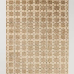 May include: A rectangular rug with a repeating geometric pattern. The rug features a beige background with a grid of squares in varying shades of brown and tan. The design is symmetrical and covers the entire surface.