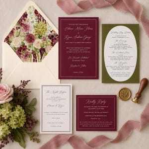 May include: A wedding invitation suite featuring a cream envelope with a floral interior, a deep burgundy main invitation, an olive green details card, a cream rehearsal dinner card, a burgundy RSVP card, and a gold wax seal stamp.