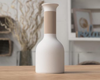 May include: A white ceramic vase with a textured surface and a cylindrical neck. The neck features a vertical, light brown, ribbed design. The vase is displayed on a light brown wooden surface, suggesting a home decor theme.