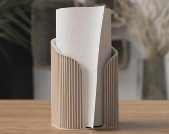 May include: A beige paper towel holder with a vertical slatted design. The holder has a curved opening to dispense paper towels. A roll of white paper towels is inside the holder, with a sheet partially pulled out.