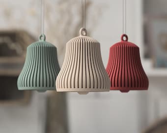 May include: Three hanging bell ornaments in sage green, beige, and deep red. Each bell features a vertical ribbed design with a small loop at the top for suspension. The bells are suspended by thin silver strings, showcasing a uniform shape.