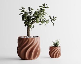 May include: Two terracotta-colored planters with a spiraling, ribbed texture. The larger planter holds a jade plant with thick green leaves, while the smaller planter contains a small, spiky succulent. Both pots are filled with white pebbles.