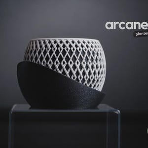 May include: A two-tone planter featuring a white upper section with a complex, repeating diamond lattice pattern and a solid black, curved lower base. The text "arcane planter" appears in the upper right, and a green "h3liø design" logo is at the bottom right.