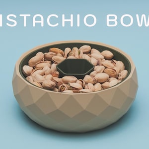 May include: A beige geometric pistachio bowl filled with pistachios, with a dark green center compartment. The words "PISTACHIO BOWL" are in white text above the bowl, set against a light blue background.