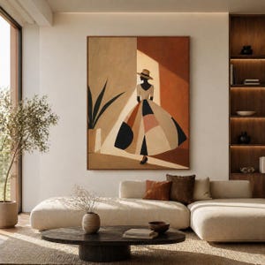 Può includere: Un dipinto astratto incorniciato raffigura una donna con cappello e vestito con motivi geometrici in una stanza dai toni neutri. L'opera d'arte presenta una tavolozza di colori beige, nero e terracotta. La stanza comprende un divano componibile beige, un tavolino in legno scuro e una libreria a muro.