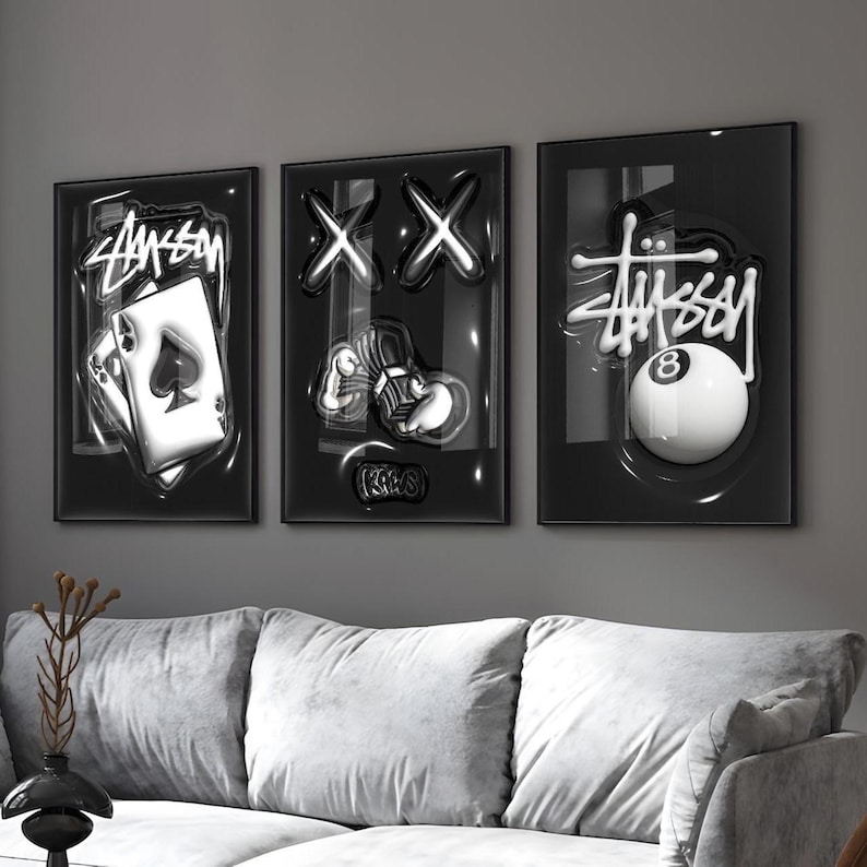 May include: A set of three black framed wall art prints featuring glossy, raised-effect graphics. The left print shows an ace of spades playing card with Stussy text. The center print displays X eyes and cartoon hands. The right print shows an 8 ball.