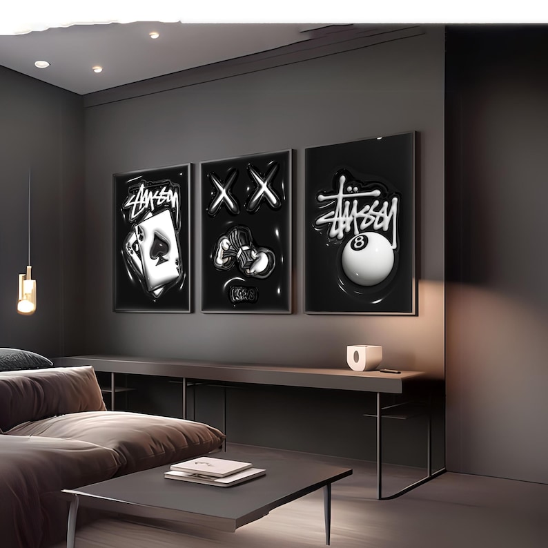 May include: Three rectangular wall art prints featuring black backgrounds with white graphic designs. The left print shows an ace of spades playing card with Stussy text. The center print displays two X symbols and a stack of cash. The right print features an eight ball with Stussy text.