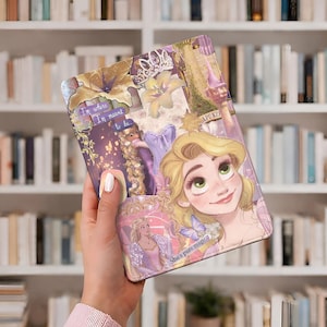 May include: A decorative tablet case featuring a collage of Rapunzel from the movie Tangled. The design includes images of Rapunzel, a castle, flowers, and the text "I'm where I'm meant to be" and "She's pure magic."