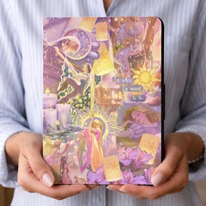 May include: A tablet case featuring a colorful illustration with a fairytale theme. The design includes images of a princess, floating lanterns, and the text "I'm where I'm meant to be." The case has a black border and a magnetic closure.