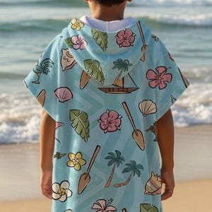 May include: A light blue hooded poncho towel featuring a repeating tropical pattern of pink hibiscus flowers, yellow plumeria, green palm leaves, brown wooden paddles, sailboats, seashells, and small island landscapes with a white interior lining.