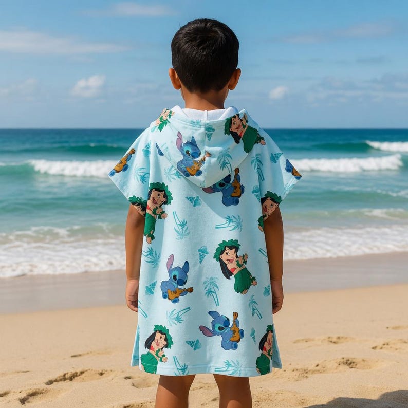 May include: A light blue hooded poncho towel featuring an all-over print of the character Stitch playing a ukulele and a character wearing a green grass skirt and floral lei, interspersed with small palm tree and seashell graphics.