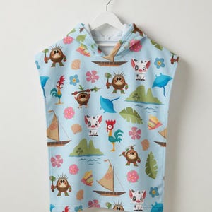 May include: A light blue hooded towel poncho featuring a repeating pattern of cartoon characters, including small brown creatures with spears, a white pig, a rooster, sailboats, tropical islands, blue stingrays, seashells, and pink flowers.