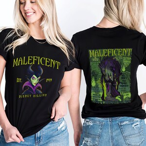 May include: Black t-shirts with a Maleficent design. The front displays "Maleficent", the year "1959", and a portrait of the character. The back features a green and black graphic. The shirts are worn by a person.
