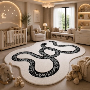 Peut inclure: Un tapis de forme irrégulière couleur crème orné d'un grand motif de serpent noir sinueux avec des marques blanches. Le tapis présente une texture douce et duveteuse et est placé sur un sol en bois dans une pièce avec un berceau et des peluches.