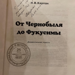 Może przedstawiać: Książka zatytułowana "Od Czarnobyla do Fukushimy" z tekstem w języku rosyjskim. Okładka zawiera pieczęć z Muzeum w Czarnobylu i odręczne notatki. Tytuł książki jest pogrubiony, czarnymi literami.