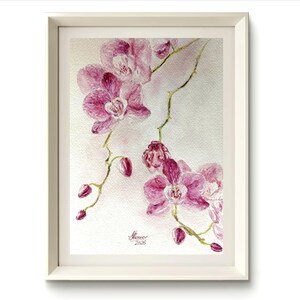Può includere: Dipinto ad acquerello di orchidee rosa in una cornice bianca. L'opera presenta fiori e boccioli dettagliati su steli delicati, con uno sfondo morbido e strutturato. La firma dell'artista e l'anno 2025 sono visibili in basso a destra.