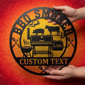 Könnte beinhalten: Schwarzes Metall-BBQ-Smoker-Schild mit den Worten "BBQ Smoker" oben und "CUSTOM TEXT" unten. Das Schild zeigt einen Grill, ein Schwein und eine Kuh. Auf beiden Seiten befinden sich gekreuzte Spatel- und Gabeldesigns.