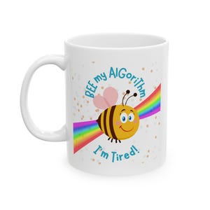May include: White ceramic mug featuring a cartoon bee design. The bee is yellow and black, with a rainbow and the text "BEE my Algorithm I'm Tired!" printed on the side. The mug has a white handle.