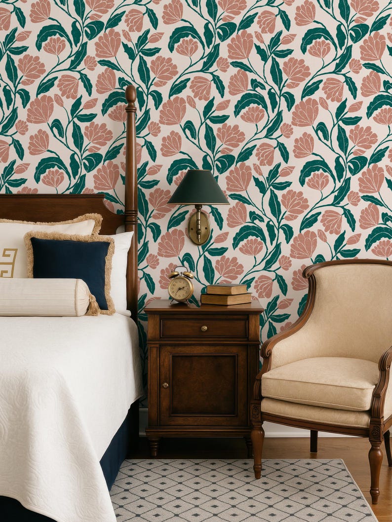 May include: A bedroom scene featuring a floral wallpaper with pink flowers and green leaves. A wooden bed frame, nightstand, and chair are visible. The bed has white bedding and navy blue pillows. A small alarm clock and books sit on the nightstand.