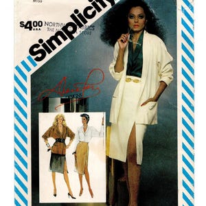 May include: Simplicity sewing pattern featuring a woman in a cream-colored skirt suit with a high slit and a matching jacket. The pattern includes illustrations of two other skirt suit designs. The text on the pattern reads "Simplicity" and "North Fabrics Store".