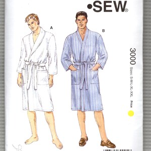 May include: A Kwik Sew pattern envelope for style 3000, featuring illustrations of two bathrobes. One is solid white and the other is blue with white vertical stripes. Both robes have a shawl collar, a tie belt, and two front patch pockets.
