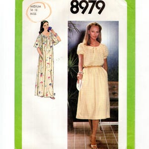 May include: Simplicity sewing pattern 8979 for a dress in size medium 14-16. The envelope features a green border and displays two dress variations: a long floral print dress with short sleeves and a solid light yellow dress with a grid pattern.