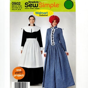 May include: Simplicity sewing pattern 0902 featuring two historical costume designs. One is a black and white pilgrim-style dress, and the other is a blue floral print dress. The pattern includes sizes U.S. 10-20.
