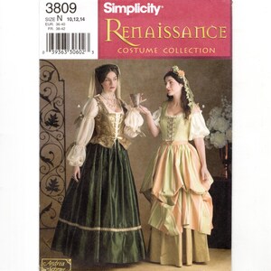 May include: Simplicity 3809 Renaissance Costume Collection sewing pattern featuring two historical-style dresses. One dress has a gold bodice and dark green skirt, the other a light green bodice with a striped skirt. Both include sheer sleeves.